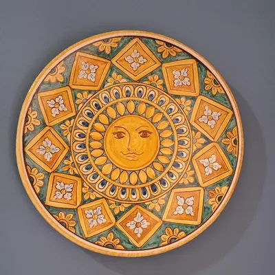 a plate with a sun on it on a wall at Nicasa, accogliente appartamento nel cuore di Palermo in Palermo