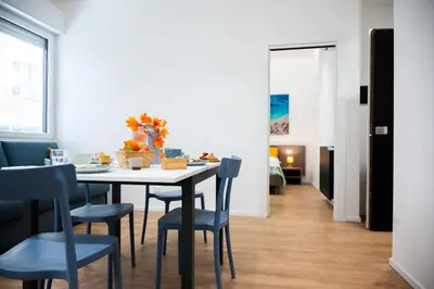 a dining room with a table and blue chairs at Appartamenti Carella Sicilia in Palermo