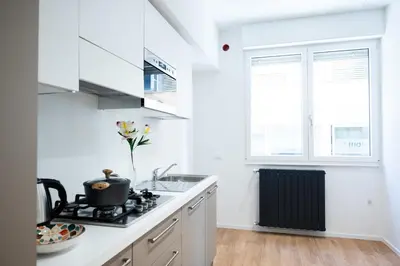 a white kitchen with a stove and a sink at Appartamenti Carella Sicilia in Palermo