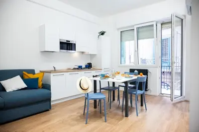 a kitchen and living room with a table and chairs at Appartamenti Carella Sicilia in Palermo