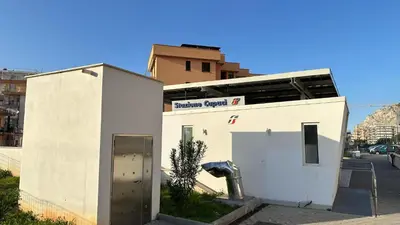 a small white building with a parking garage at Paradiso del mare, Appartamento accogliente vicino a mare, metro, aeroporto e Palermo in Capaci