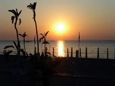 a sunset on the beach with the sun setting at Paradiso del mare, Appartamento accogliente vicino a mare, metro, aeroporto e Palermo in Capaci