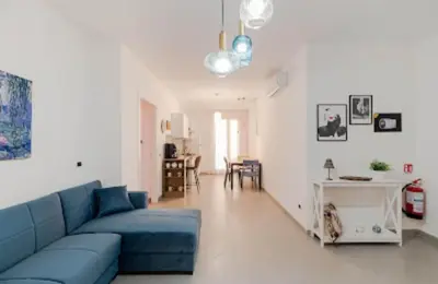 a living room with a blue couch and a table at Paradiso del mare, Appartamento accogliente vicino a mare, metro, aeroporto e Palermo in Capaci