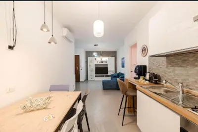 a kitchen and living room with a counter and a sink at Paradiso del mare, Appartamento accogliente vicino a mare, metro, aeroporto e Palermo in Capaci