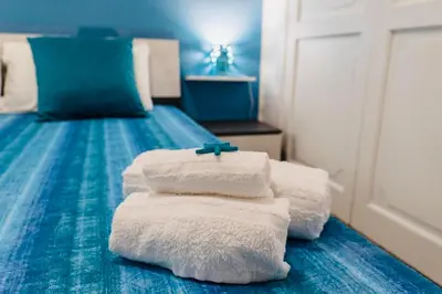 a pile of towels sitting on top of a bed at DV holiday home in Isola delle Femmine