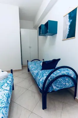 a bedroom with a bed and a couch in a room at DV holiday home in Isola delle Femmine