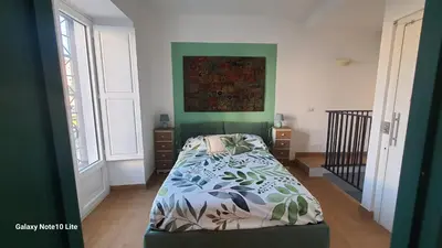 a bedroom with a bed and a painting on the wall at Le Calette Palermo in Palermo