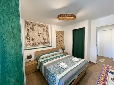 a bedroom with a bed and a green curtain at VFH Residence Flavia -Tre Piscine in Santa Flavia