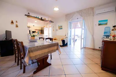 a kitchen and living room with a table and chairs at Liberia vacanze - A POCHI PASSI dal mare in Alcamo