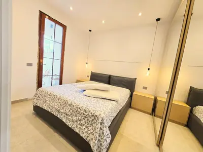 a bedroom with a bed and a mirror at Villa Lumos Mondello Beach in Palermo