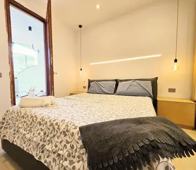 a bedroom with a large bed with a large window at Villa Lumos Mondello Beach in Palermo