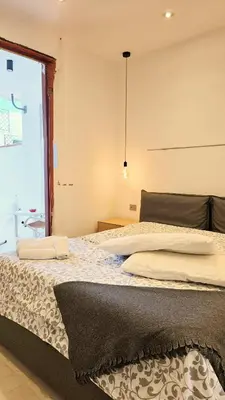 a bedroom with a large bed with a window at Villa Lumos Mondello Beach in Palermo