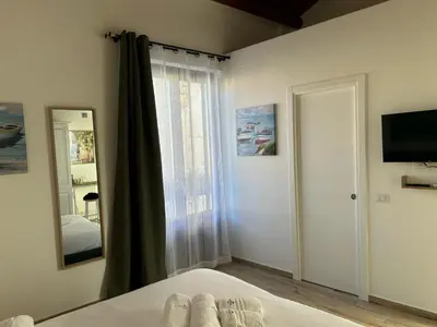 a bedroom with a bed and a mirror and a window at Tuppulia appartamenti in Palermo