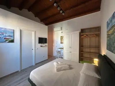 a bedroom with a large white bed and a desk at Tuppulia appartamenti in Palermo