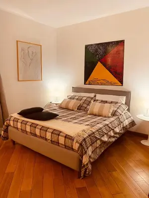 a bedroom with a bed and a painting on the wall at Cate Home historic center in Palermo