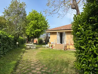 a small yellow house with a yard with a bench at Mondello Key loft in Palermo