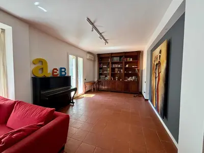 a living room with a red couch and a piano at Mondello Key loft in Palermo