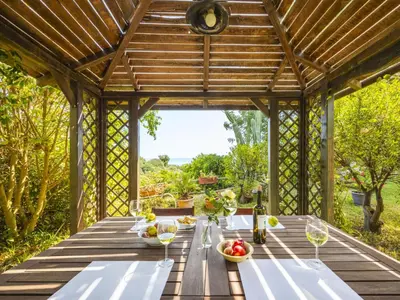 a wooden table in a pergola with food on it at Apartment Cicladi Santorini by Interhome in Santa Flavia