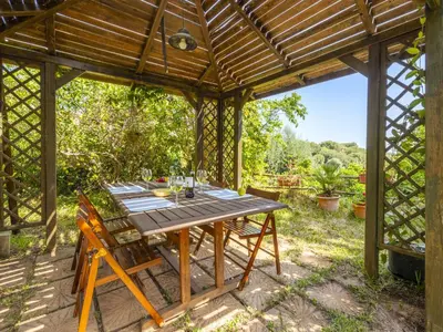 an outdoor dining area with a wooden pergola at Apartment Cicladi Santorini by Interhome in Santa Flavia