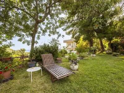 a wooden bench sitting in the grass in a yard at Apartment Cicladi Kea by Interhome in Santa Flavia