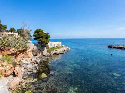 a body of water with a building on a cliff at Apartment Cicladi Kea by Interhome in Santa Flavia