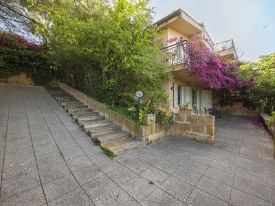 a house with stairs next to a building with flowers at Apartment Cicladi Amorgos by Interhome in Santa Flavia