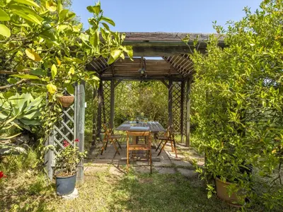 a table and chairs under a pergola in a garden at Apartment Cicladi Amorgos by Interhome in Santa Flavia