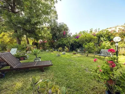 a garden with benches and flowers and plants at Apartment Cicladi Paros by Interhome in Santa Flavia