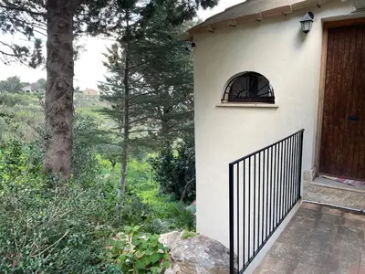 a building with a gate next to a tree at Lally in the Sky moderno monovano panoramico ed accessoriato in Scopello
