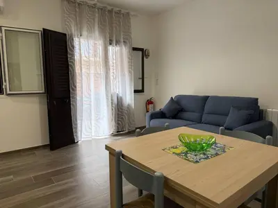 a living room with a table and a blue couch at Casa Francesca in Capaci