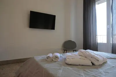 a bedroom with towels on a bed with a television at Courthouse Apartments Palermo in Palermo