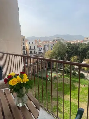 a vase of flowers sitting on a bench on a balcony at Courthouse Apartments Palermo in Palermo