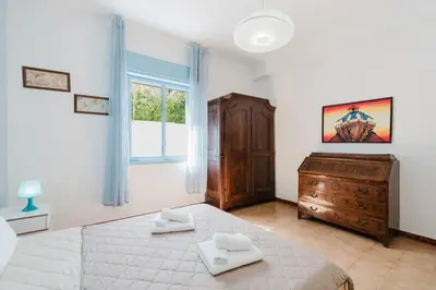 a bedroom with a bed and a dresser and a window at Archi in Balestrate