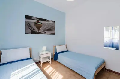 a room with two beds and a picture on the wall at Archi in Balestrate