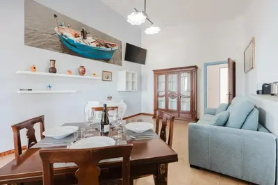 a living room with a table and a blue couch at Archi in Balestrate