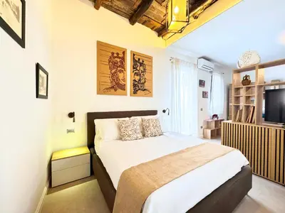 a bedroom with a large bed and a television at Helena Apartments - Secondo Canto in Palermo