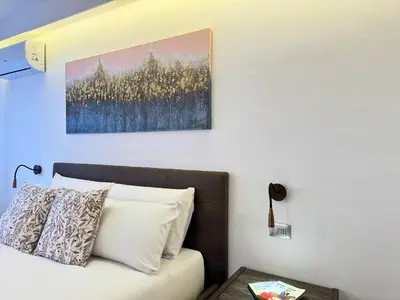 a bedroom with a bed and a painting on the wall at Helena Apartments - Secondo Canto in Palermo