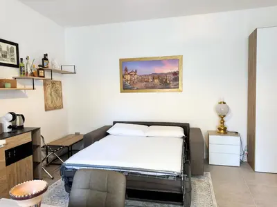 a bedroom with a bed and a chair in it at Helena Apartments - Secondo Canto in Palermo