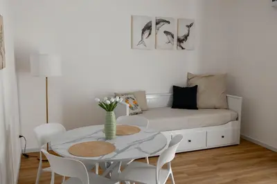 a white living room with a table and a couch at MonSea in Palermo