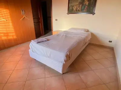 a small bed in a room with a tiled floor at Villa Sunset in Campofelice di Roccella
