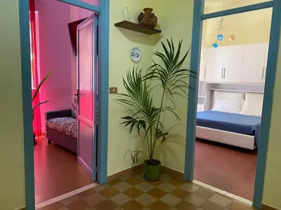 a room with a potted plant and a bedroom at irenes holiday house in Palermo