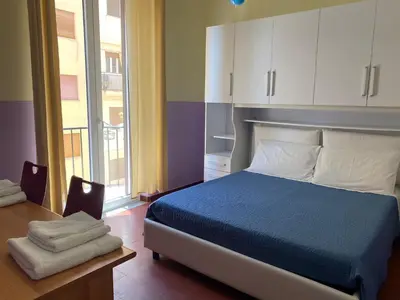a bedroom with a bed and a table and a window at irenes holiday house in Palermo