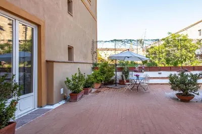 a patio with a table and an umbrella on a building at Palazzo De Gregorio - Apartments in Palermo