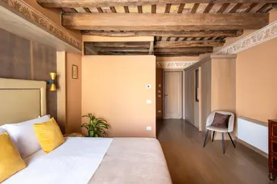 a bedroom with a bed and a chair at Palazzo De Gregorio - Apartments in Palermo