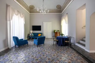a living room with blue chairs and a table at Palazzo De Gregorio - Apartments in Palermo
