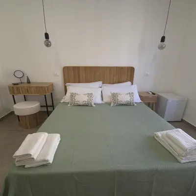 a bedroom with a large green bed with towels on it at La Ciconella 2 in Palermo
