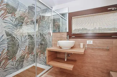 a bathroom with a sink and a glass shower at Villa Al-Kurum in Alcamo Marina