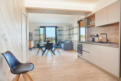 a kitchen and living room with a table and chairs at Villa Al-Kurum in Alcamo Marina