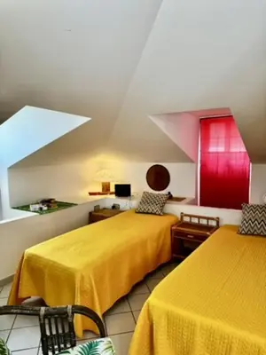 two beds in a room with yellow sheets at Villa Tocco vicino al mare in Balestrate