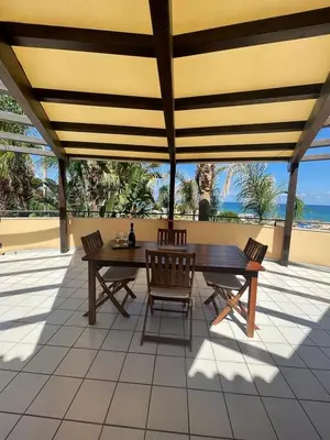 a table and chairs on a patio with a view of the ocean at Villa Tocco vicino al mare in Balestrate